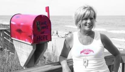Sue Goodrich poses with the first Little Red Mailbox in Kill Devil Hills. Photo OBX Beach Bum.