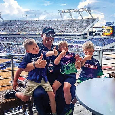 Dennis Anderson seated with grandsons, Race, Luke and Wade.