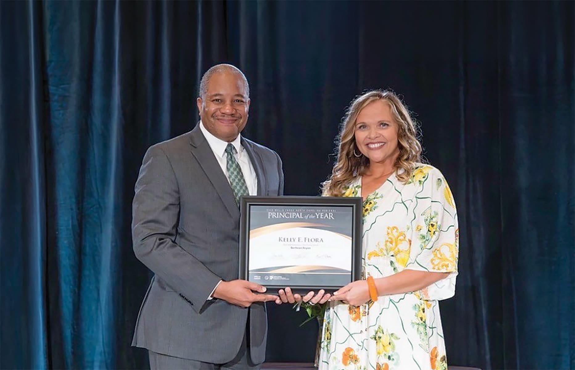 Jason Johnson, the 2025 North Carolina Principal of the Year, presents the award to Kelly Flora in a moment of honor and recognition.